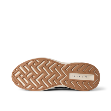Reef Zuma sneaker close-up, outsole facing up with toe pointing left and heel right, showing textured tread and cushioned sole