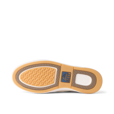 Bottom sole of a REEF shoe facing upward showing tread pattern and logo in tan, brown, and white colors.