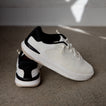 Reef Del Mar white sneakers, one facing right and another showing the heel, with lightweight cushioned comfort