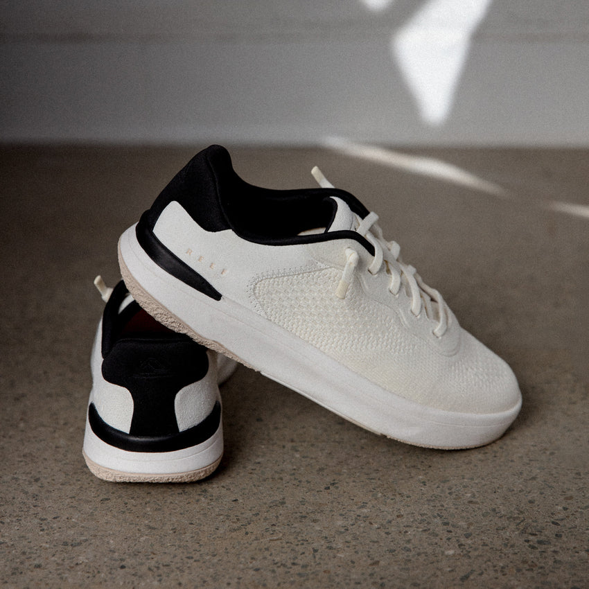 Reef Del Mar white sneakers, one facing right and another showing the heel, with lightweight cushioned comfort