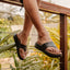 Cali Laguna black platform sandals with toes facing right and cushioned footbeds in a tropical lifestyle setting