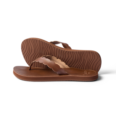 Pair of Reef Cushion Celine sandals in chocolate brown, left facing, showing sole tread and scalloped straps close-up.