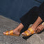 Cushion Vista sandals in tan, worn on feet facing left, showcasing lightweight, arch support beach-inspired design.