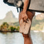 Seaside Twist sandals held in right hand facing down, showcasing soft-rebound cushioning and water-friendly design.