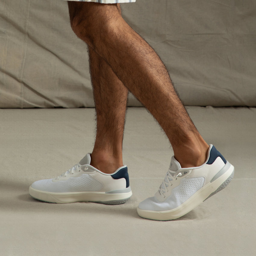Side view of Shoreline Del Mar sneaker on feet, white with navy heel, showing lightweight design and comfort features.