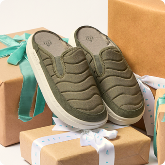 Olive green slip on shoes facing the viewer, with cushioned wavy upper panels on wrapped boxes