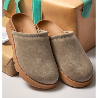 Pair of taupe clogs facing forward, showing rounded toes, textured uppers, and tan soles.