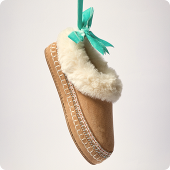 Brown fuzzy lined slipper facing upper left with a teal ribbon and stitched sole