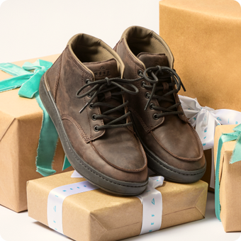 Pair of brown lace-up shoes facing forward on wrapped gift boxes