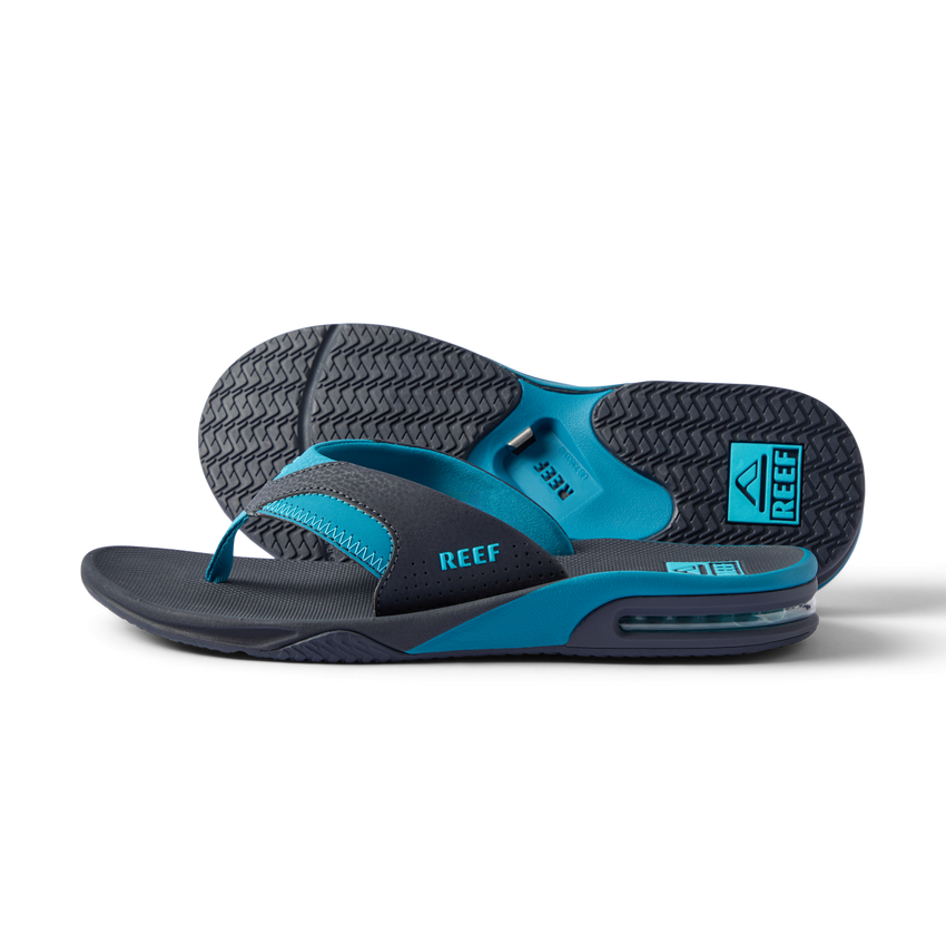 REEF Fanning men's flip flops facing left, shown from the side with cushioned footbeds and textured rubber outsoles
