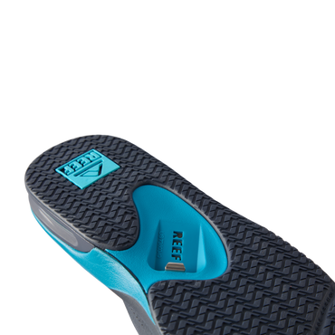 REEF Fanning flip flop outsole facing viewer, toe pointing upper left, close-up of textured tread and arch support