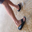 Fanning H2O facing right on feet stepping into shallow water, men's black water-friendly sandals with arch support and cushioned footbed