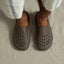 Top-down view of feet wearing brown Glider slides facing forward, showcasing water-friendly perforated toes and seamless comfort design.
