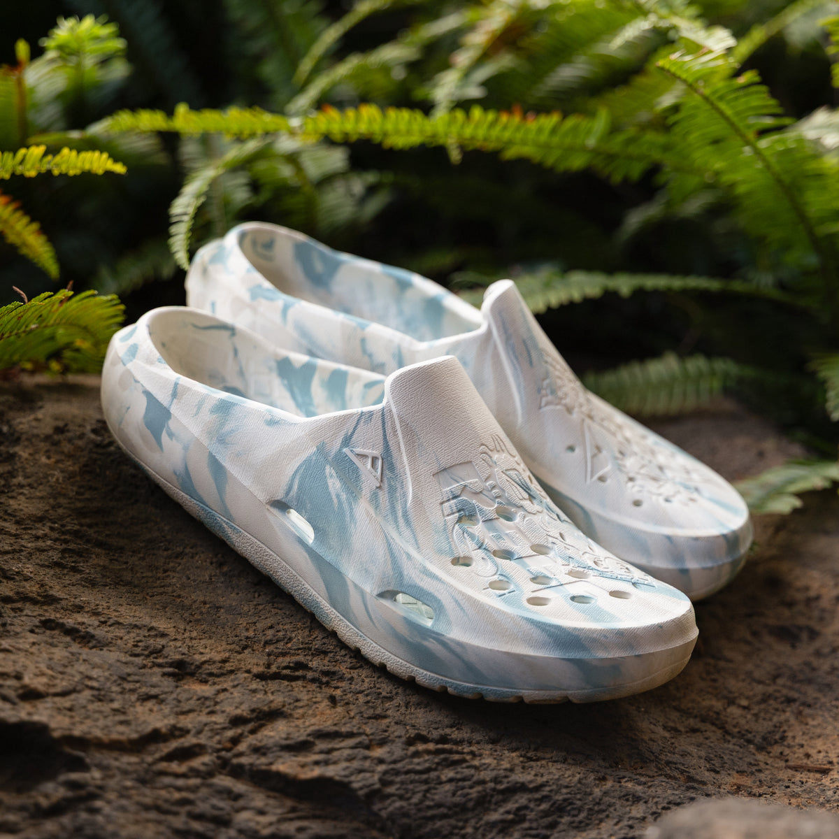 Glider water friendly shoes facing toward the viewer with perforations and cushioned footbeds in a beach inspired blue pattern
