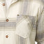 Close-up of the pocket and buttons on the Houston Flannel Shirt in almond milk with a soft plaid pattern.