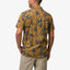 Back view of men's Kantis Shirt in buckthorn brown with blue tropical leaf print, showcasing comfort and surf-inspired style.