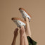 studio shot of woman wearing white and brown reef sneakers