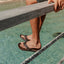 Leather Offshore men’s sandals in dark brown facing left, close-up of footbed and straps above water background.