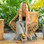 Woman seated on wicker chair wearing black Vista Hi Layla sandals facing forward, showcasing comfort and beach style