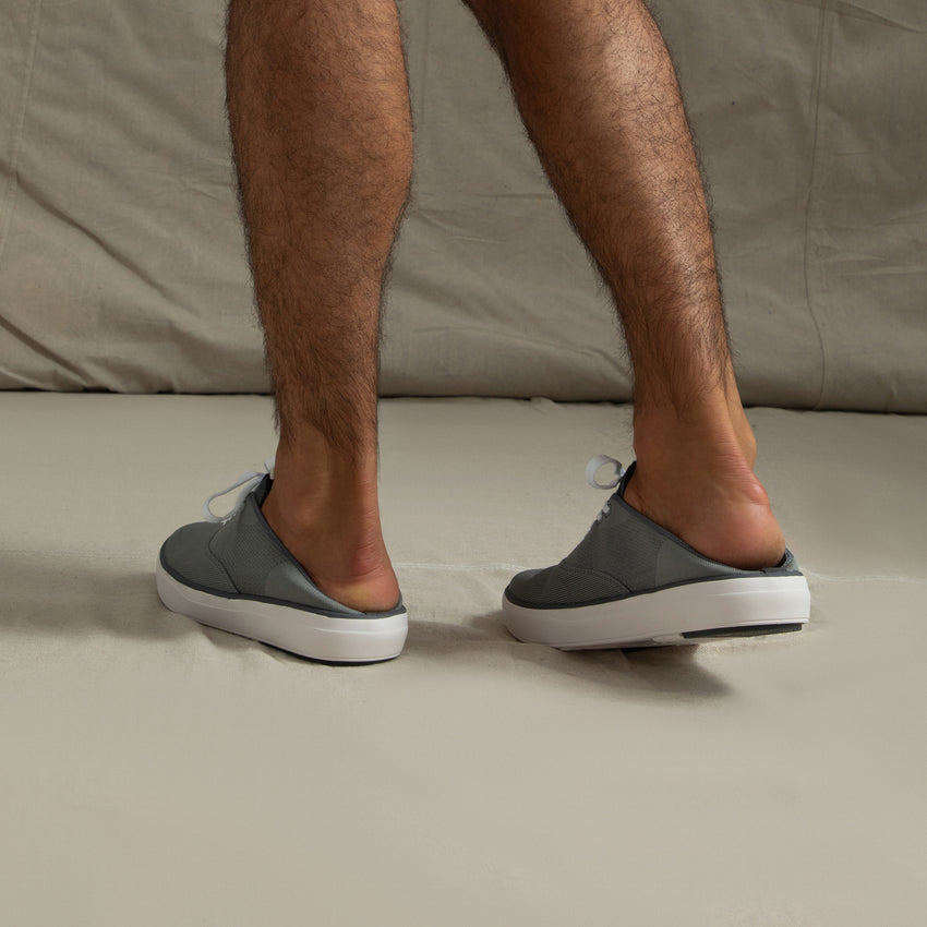 Rear view of men's Neptune Lido grey sneakers worn as slip-ons, showing soft cushioning and durable outsole for beach comfort.