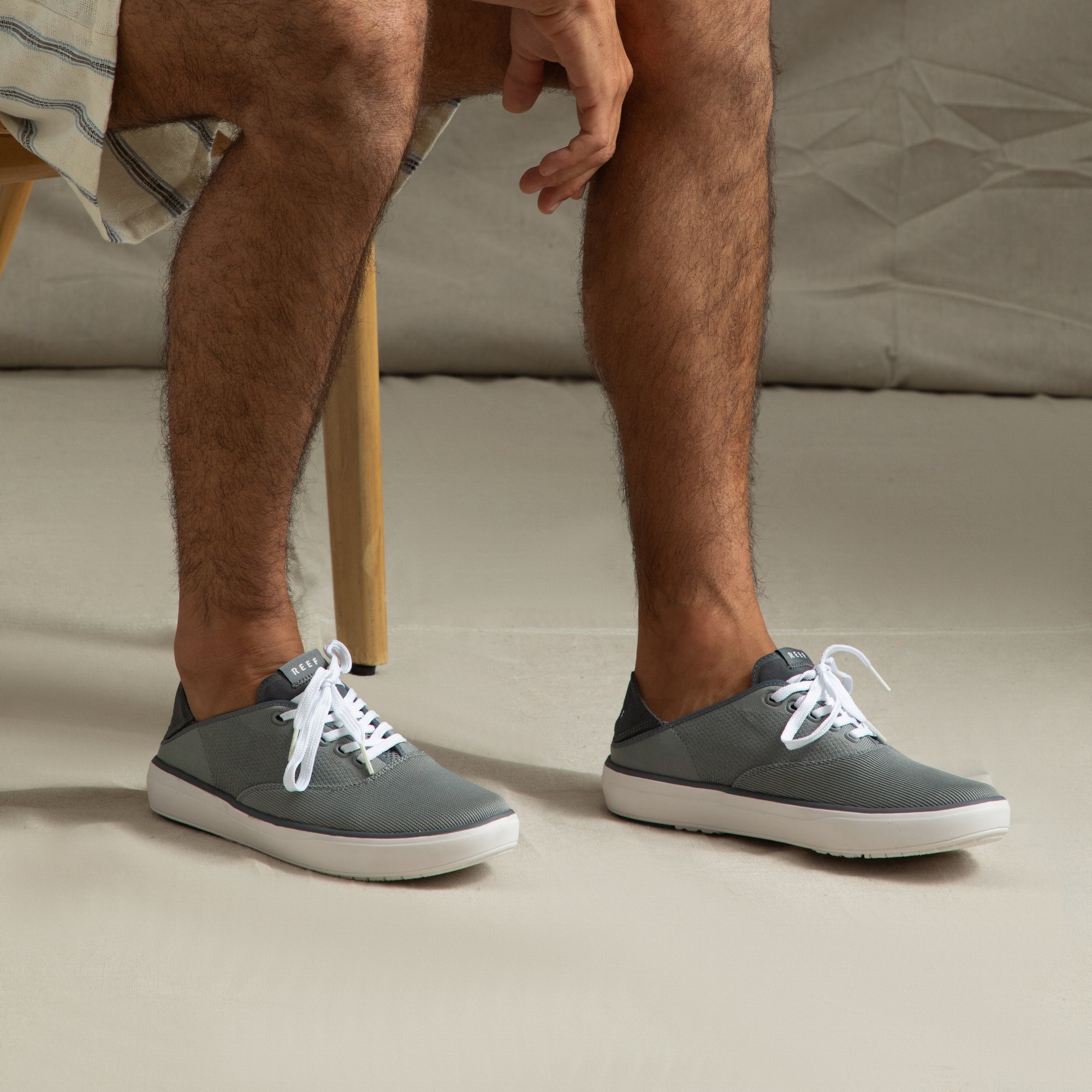 Neptune Lido grey sneakers facing right, showing side and top views with white laces, highlighting extra cushioning and arch support.