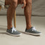 Neptune Lido grey sneakers facing right, showing side and top views with white laces, highlighting extra cushioning and arch support.