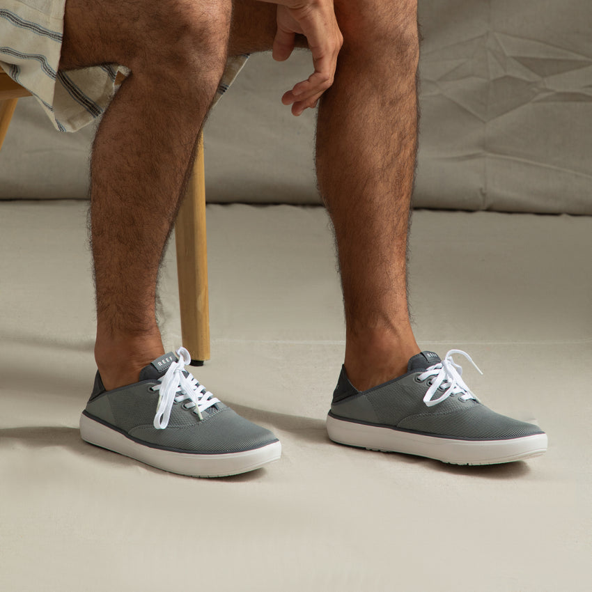 Neptune Lido grey sneakers facing right, showing side and top views with white laces, highlighting extra cushioning and arch support.