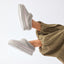 Mikayla grey plush faux fur lined footwear with soles facing left and toward the viewer