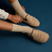 Men's Cushion Homey slip-on footwear in acorn color shown from left side, highlighting quilted upper and comfort design.