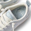 Close-up top view of the Neptune Alana sneaker laced and facing forward with cushioned collar in light blue textile.