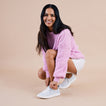 Woman crouching while wearing Neptune Alana sneakers facing left, showing side and top with soft-rebound cushioning.