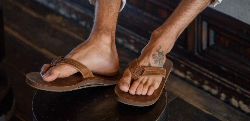 Man sitting at a cafe wearing the Draftsman Leather Sandal.