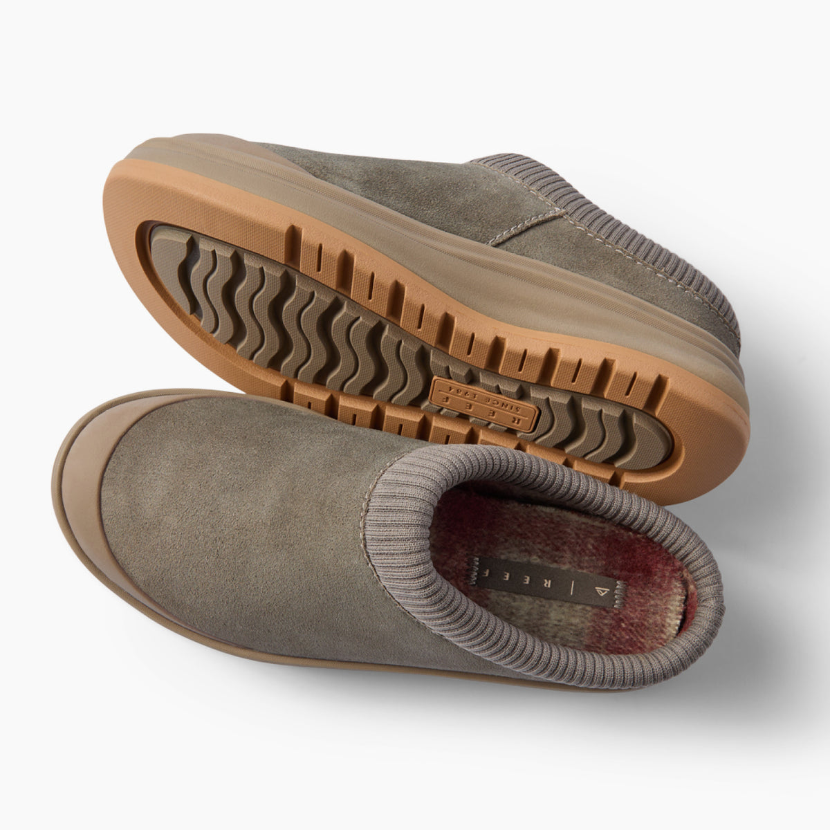 Pair of gray slip-on shoes facing left, one showing its textured outsole and the other showing its cushioned footbed