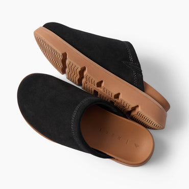 Vista Luxe Mariana black suede clogs facing left with textured soles and cushioned footbeds