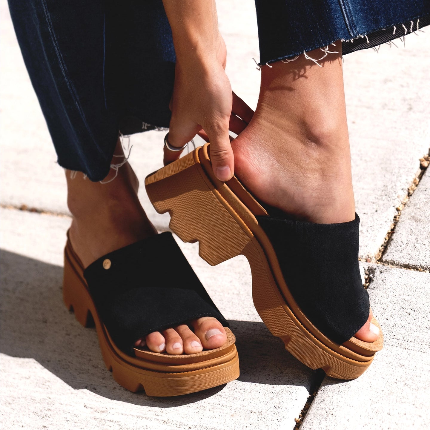 Vista Luxe Evie showing right foot sliding into black suede mule facing left with thick platform sole, soft cushioning design.