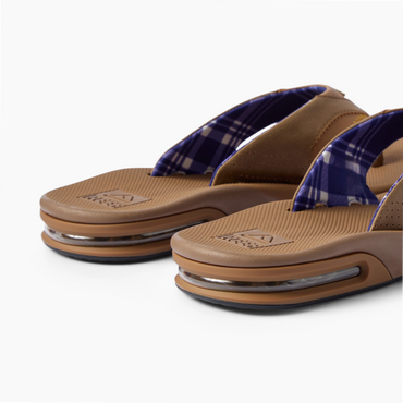 Fanning men's flip flops facing left, close-up of cushioned footbeds and plaid straps