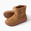 Pair of tan ankle boots facing left, featuring ribbed collars, stitched panels, and textured rubber soles.