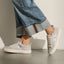 Lay Day Lite silver sneakers, one facing left and one right, styled with wide leg jeans for comfortable everyday wear