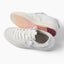 Kickback white sneakers facing left, with lace up uppers and textured pink outsoles for beach inspired comfort