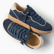 Kickback navy sneakers, one facing right and one angled toward the viewer, with cushioned soles
