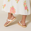 Vista Carmen sandals showing the left shoe from the side and heel with white straps and a woven sole, worn by a woman.