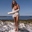 Woman wearing Cushion Slim sandals facing forward on rocky beach landscape under clear sky