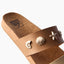 Cushion Vista women's tan sandal facing left, close-up of the front strap with seashell embellishments, beach-inspired comfort.