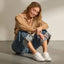 Lay Day Lite white sneakers with toes facing forward on a seated model, showcasing comfortable everyday style
