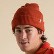 Close-up of a man wearing a chili red Alyx Beanie with a folded cuff, surf-inspired and unisex design.