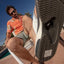 Fanning flip flop sole close-up facing camera, showcasing durable rubber tread and bottle opener, beach-ready comfort style.