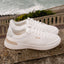 Pair of white Shoreline Palisades sneakers facing right, showing knit upper and cushioned sole for beach comfort.