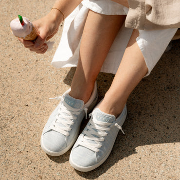 Close-up of feet wearing Neptune Alana sneakers facing forward in soft blue with extra cushion and arch support, beach-inspired comfort.