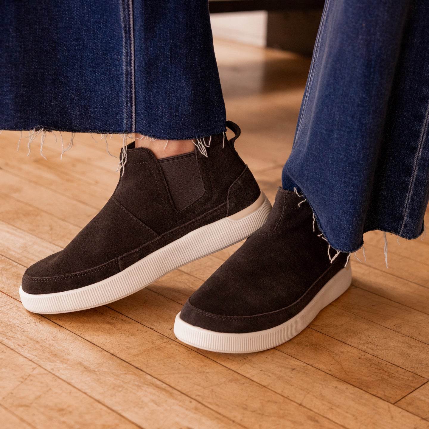 Neptune Athena shoes facing right and left, black suede with white sole, showcasing casual comfort and arch support features.