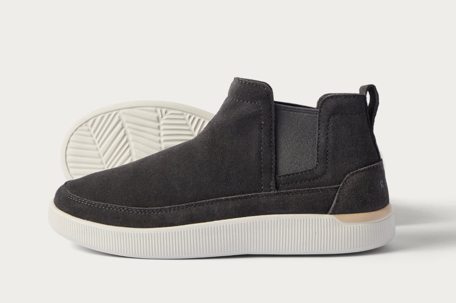 Side view of black surf-inspired sneaker facing right with cushioned sole and arch support features